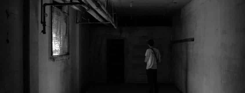 Young man exploring dark, unfinished Hamilton basement
