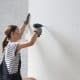 Female home contractor drilling screw holes in drywall