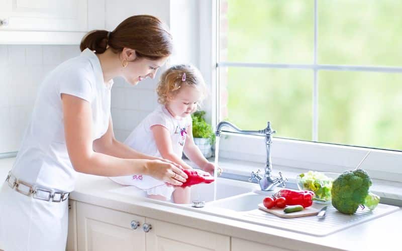 Mother and her Daughter washing vegetables